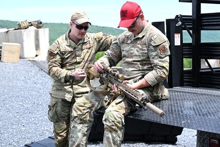 Airman First Class Liam Regan and Staff Sgt Colin King, both assigned to the 107th Attack Wing Security Forces Squadron, inspect the M110A1 sniper rifle before beginning qualification training on May 20, 2025 at Fort Indiantown Gap, PA. Qualification on the M110A1 sniper rifle is limited to those who demonstrate advanced marksmanship and complete the two-week Advanced Designated Marksman Course, held at Fort Bliss, Texas. New York Air National Guard photo by Capt Jason Carr.