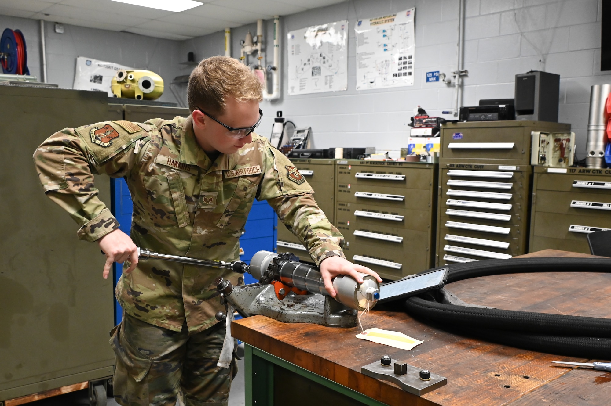 U.S. Air Force Senior Airman Riley Hawkins, a member of the hydraulics shop at the 117th Air Refueling Wing, reassembles an aircraft part after repair.