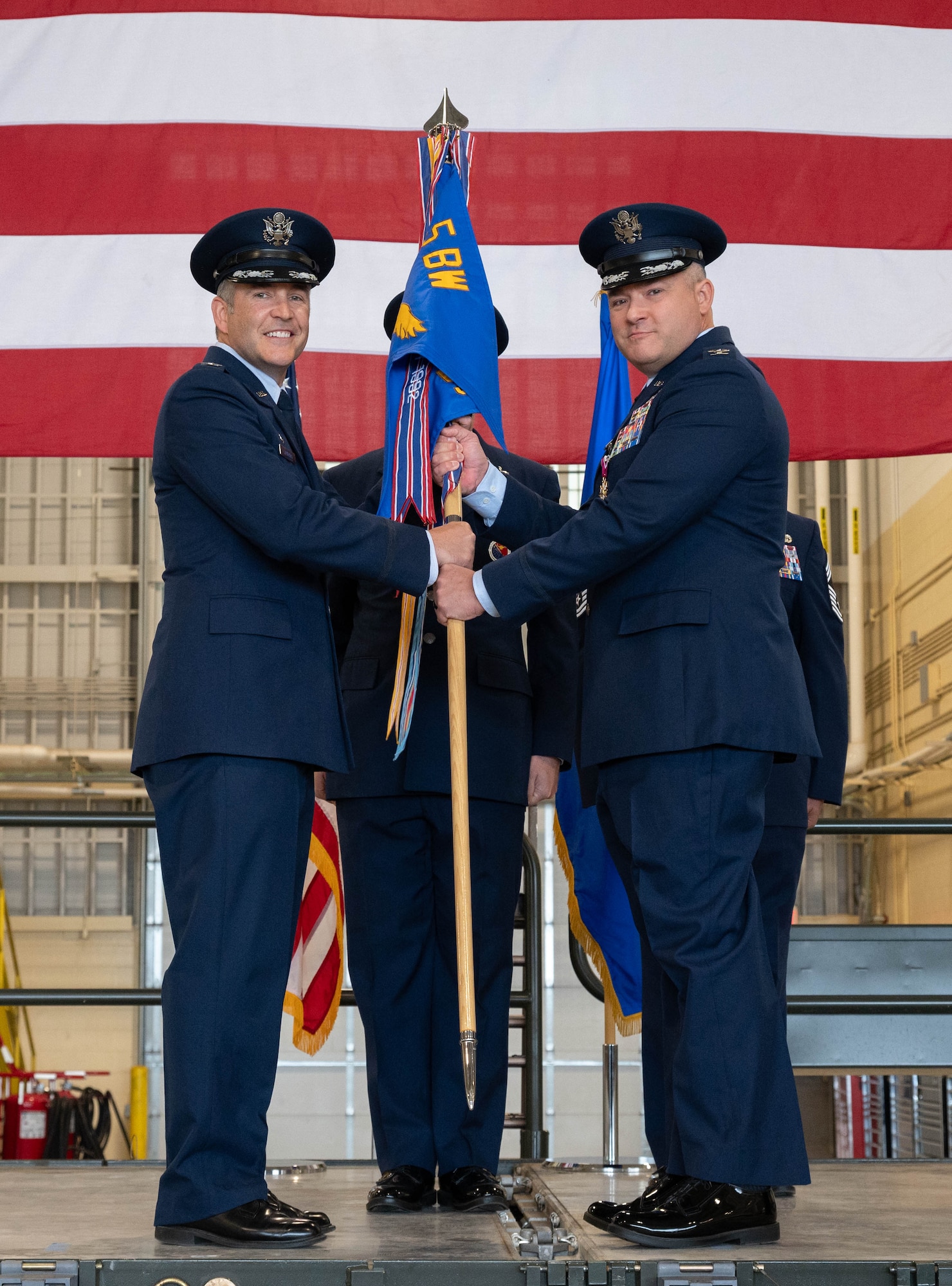 U.S. Air Force Col. Jesse Lamarand, 5th Bomb Wing commander (left), presents U.S. Air Force Col. Jerry Ottinger, 5th Mission Support Group (5MSG) commander (right), with the 5MSG guidon during a change of command ceremony at Minot Air Force Base, North Dakota, June 2, 2025. Ottinger led six squadrons providing full spectrum operational and expeditionary support to the 5th Bomb Wing, the 91st Missile Wing and the 54th Helicopter Squadron, delivering global assurance, precision strike, and nuclear deterrence to six combatant commanders. (U.S. Air Force photo by Airman 1st Class Wesley Davies)