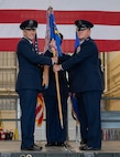 U.S. Air Force Col. Richard Zeigler, incoming 5th Mission Support Group (5MSG) commander (right), accepts the 5MSG guidon from U.S. Air Force Col. Jesse Lamarand, 5th Bomb Wing commander (left), during a change of command ceremony at Minot Air Force Base, North Dakota, June 2, 2025. Lamarand passed the guidon to Zeigler during the ceremony, symbolically passing command of the 5MSG. (U.S. Air Force photo by Airman 1st Class Wesley Davies)