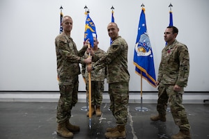 U.S. Air Force Col. Ross E. Dotzlaf, right, incoming 1st Expeditionary Theater Support Group commander, assumes command of the 1st ETSG during the change of command ceremony within the U.S. Central Command area of responsibility, May 30, 2025. The ceremony saw Col. Matthew Borawski, outgoing 1st ETSG commander, relinquish command to Dotzlaf. (U.S. Air Force photo by Senior Airman Dieondiere Jefferies)