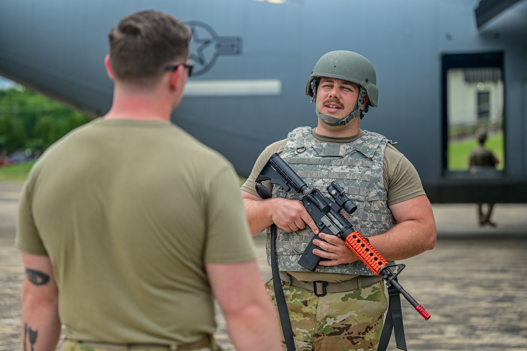 Two Airmen gather in front of a C130J Super Hercules aircraft.