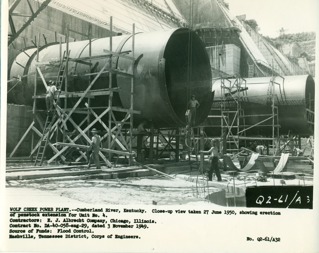 Crews erect the penstock extensions for the Wolf Creek Dam Powerhouse June 27, 1950, on the Cumberland River in Jamestown, Kentucky.  The multi-purpose dam would serve to replace the old locks and dams on the Cumberland River. (USACE Photo)