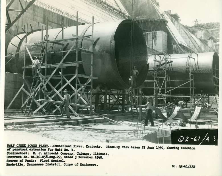 Crews erect the penstock extensions for the Wolf Creek Dam Powerhouse June 27, 1950, on the Cumberland River in Jamestown, Kentucky.  The multi-purpose dam would serve to replace the old locks and dams on the Cumberland River. (USACE Photo)