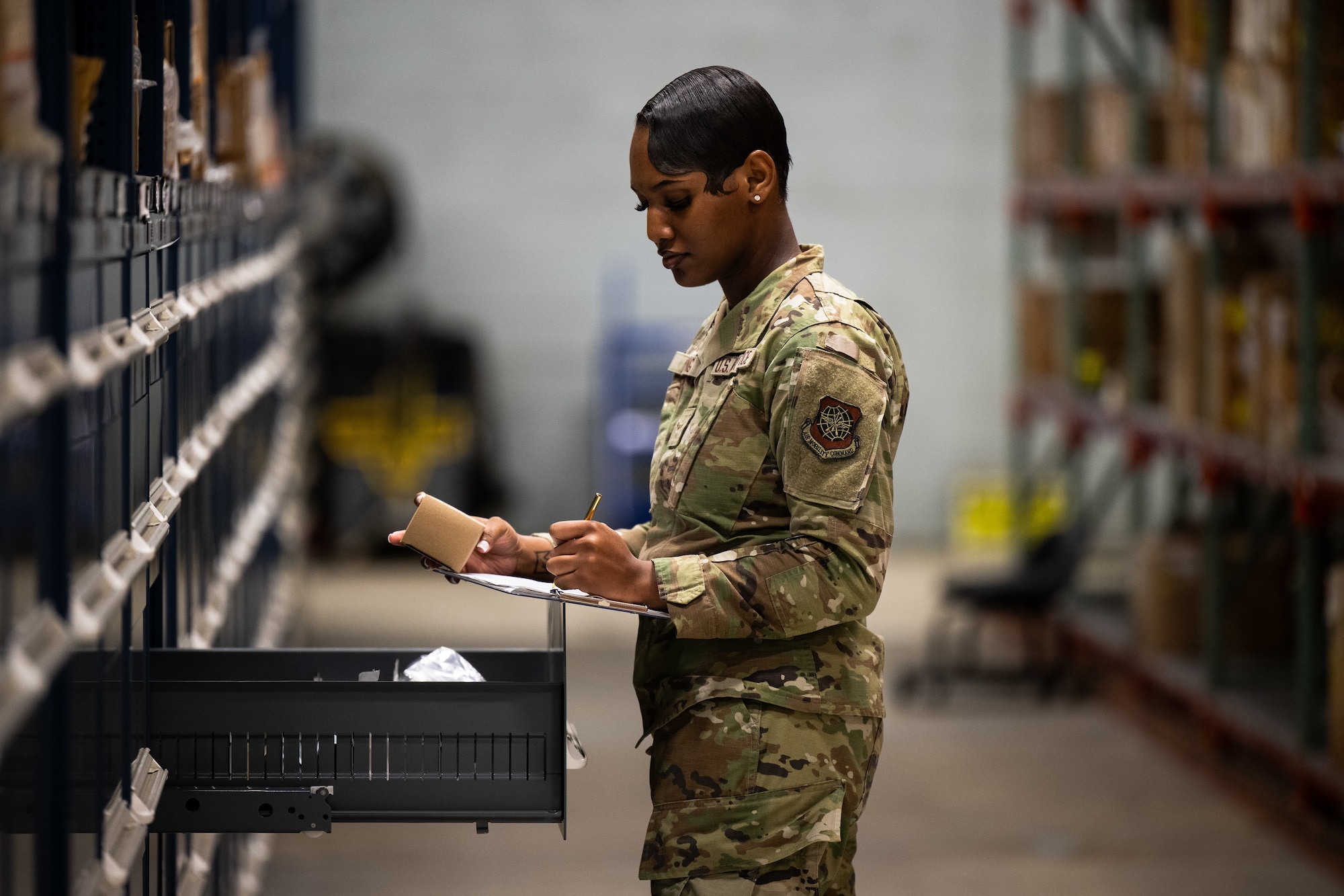U.S. Airman 1st Class Shanelle King, 436th Logistics Readiness Squadron material management inspection apprentice, writes while inspecting parts at Dover Air Force Base, Delaware, June 2, 2025. As part of the Material Management Flight within the 436th LRS, King is responsible for ensuring compliance and accountability across the base by conducting shelf-life inspections, functional checks and Care of Supplies in Storage (COSIS). She also trains and certifies limited inspectors to maintain readiness across the unit. (U.S. Air Force photo by Staff Sgt. Marco A. Gomez)