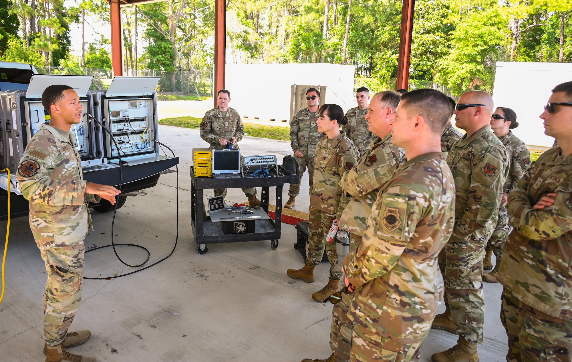 U.S. Air Force Senior Airman Tavion Cox, 87th Electronic Warfare Squadron COMBAT SHIELD avionics electronic warfare journeyman, briefs visiting 2A maintenance functional managers on the COMBAT SHIELD mission during a wing immersion tour at Eglin Air Force Base, Fla., May 28, 2025. The immersion lasted two days and allowed the visiting functional managers to engage with all A2s across the 350th Spectrum Warfare Wing to learn more about their unique electromagnetic warfare specific duties. (U.S. Air Force photo by Capt. Benjamin Aronson)