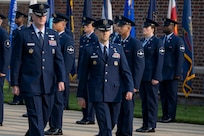 Air and Space Force personnel perform ceremonial assumption of command in dress uniform.
