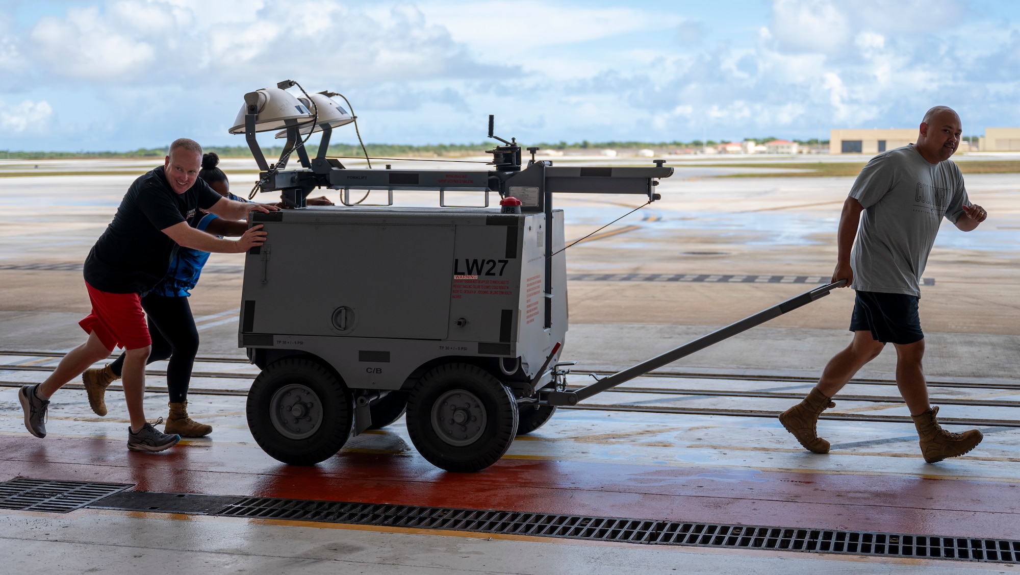 From left, Tech. Sgt. Daniel Williams, assigned to the 36th Maintenance Squadron; Senior Master Sgt. Tiona Jones, first sergeant with the 36th Civil Engineer Squadron; and Tech. Sgt. Anthony Yallum, also with the 36th Maintenance Squadron, move a large piece of equipment during the Maintenance Olympics at Andersen Air Force Base, Guam, May 30, 2025.
