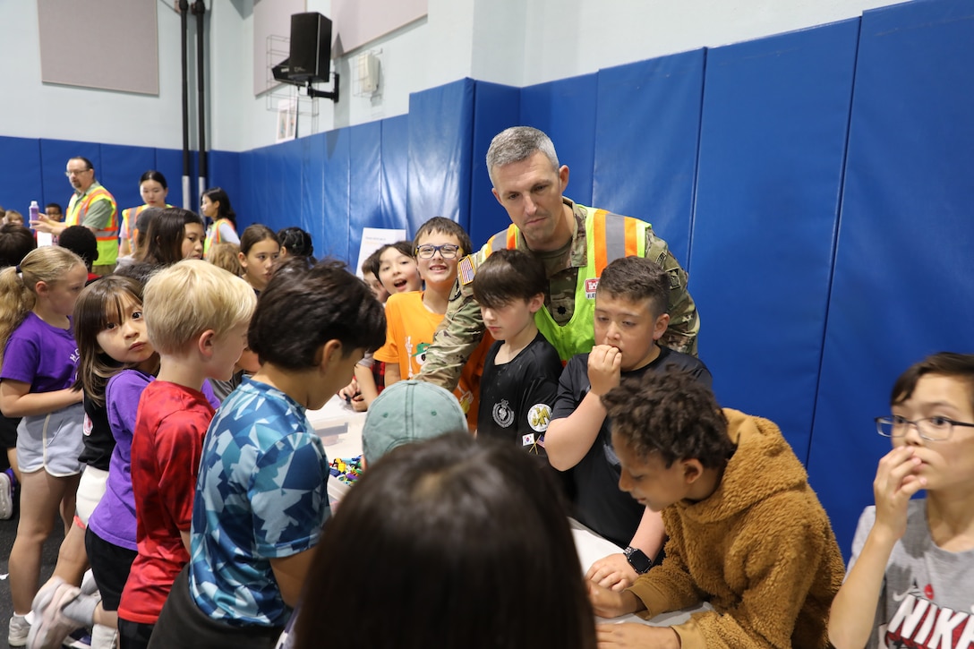 Staff Sgt. Kyler Hughes, Construction Control Representative, U.S. Army Corps of Engineers – Far East District, guides students in creating "Ocean in a Bottle" during a Science, Technology, Engineering, Arts and Mathematics (STEAM) event hosted by USACE at West Elementary School on Camp Humphreys, South Korea, on May 22, 2025. Highlighting the vital role of STEAM in our everyday lives, Hughes sparks excitement for science and engineering in young minds. (U.S. Army photo by Yohan An)