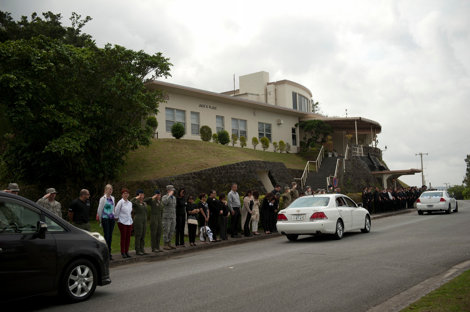 Team Kadena members and friends of Sadamu Jack Oshiro stand for a memorial procession convoy outside of Jack’s Place at Kadena Air Base, Japan, March 18, 2016.