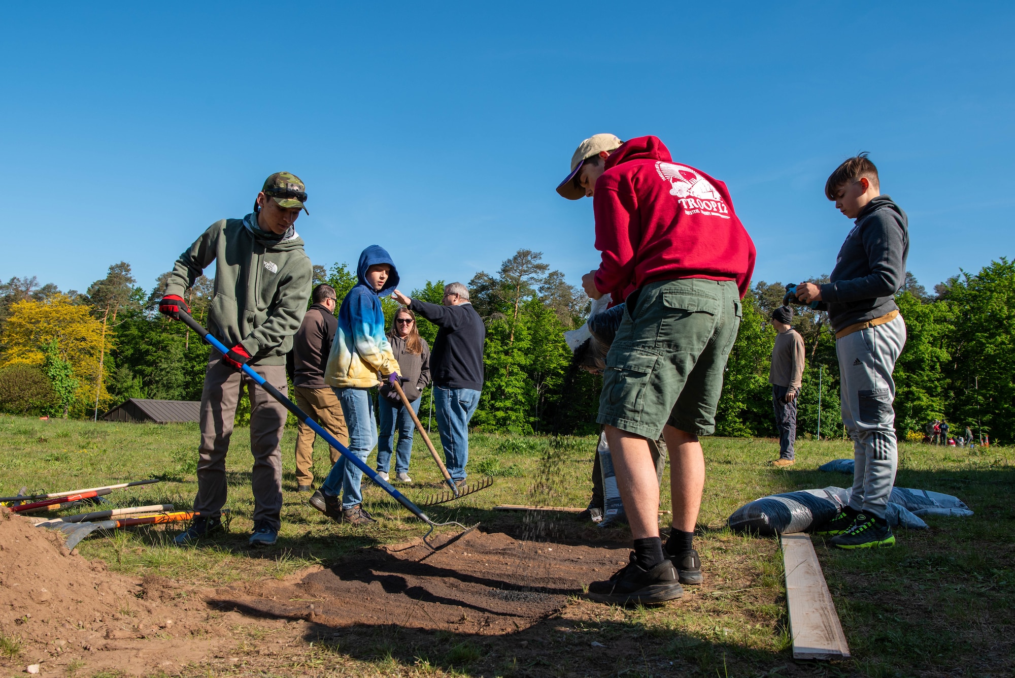 Boy Scouts of America members clear and level terrain for a future disc golf course.