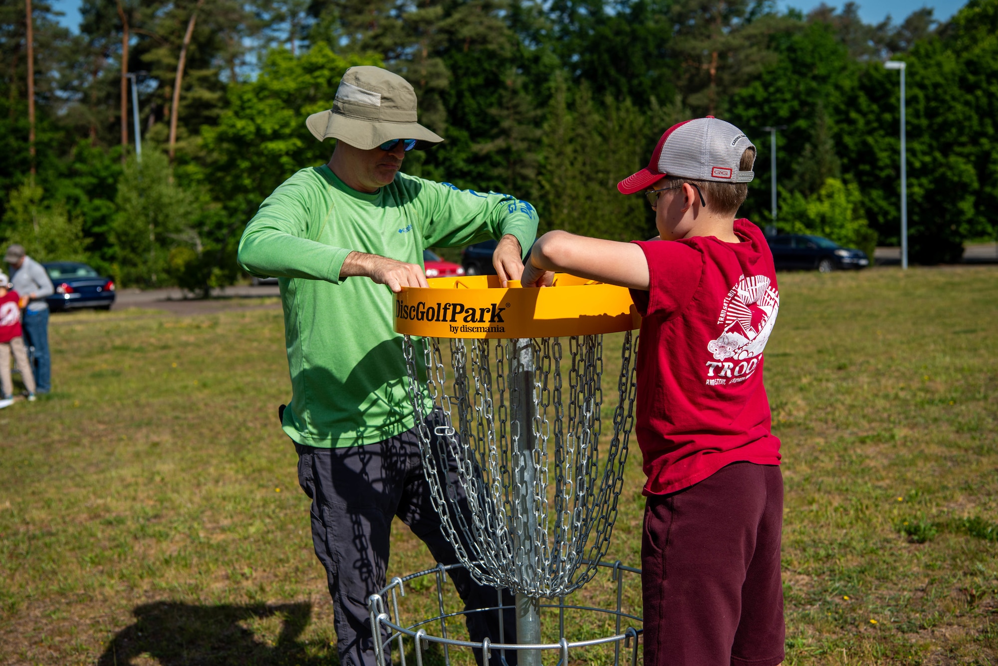 Boy Scouts of America members assemble a disc golf basket.