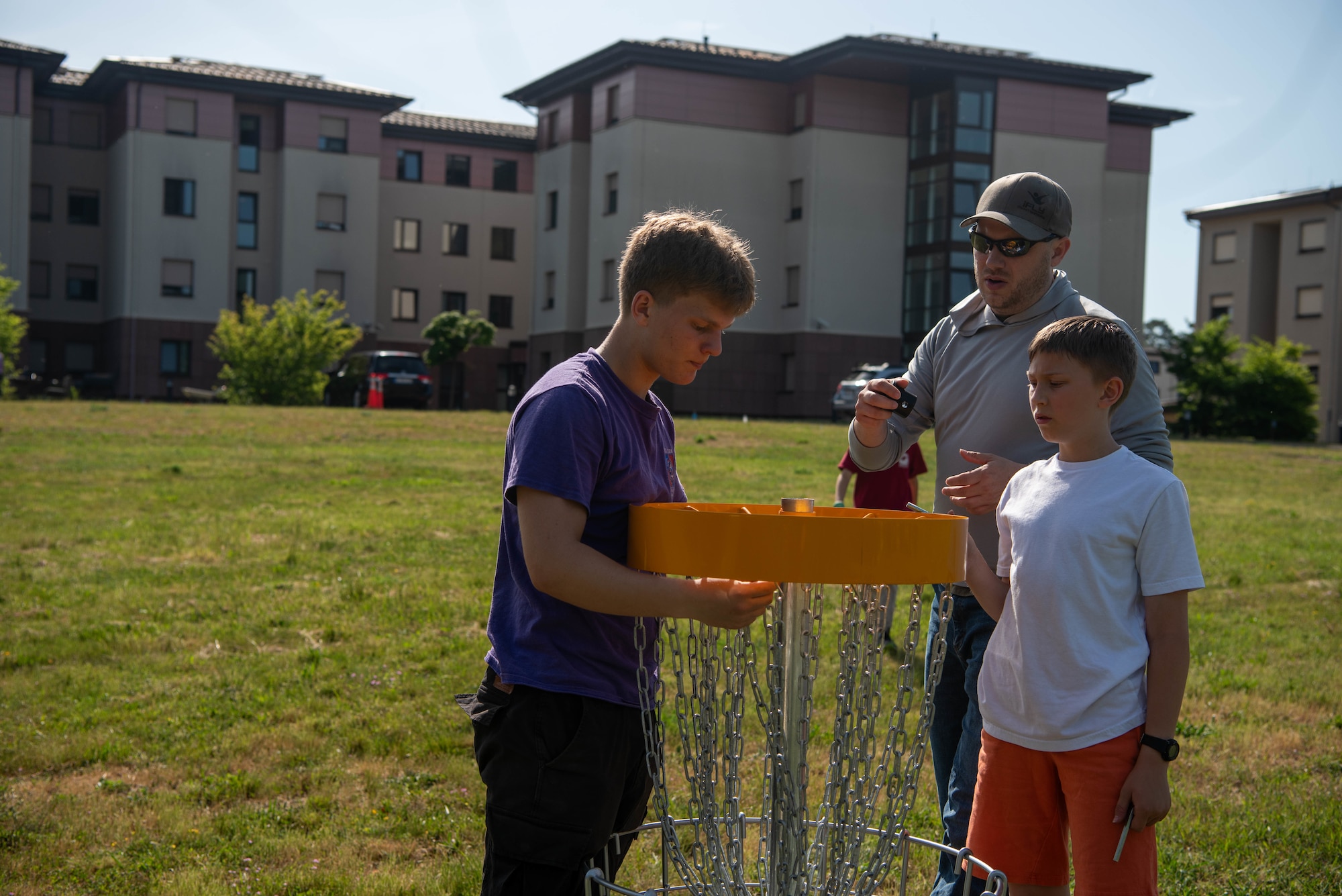 Boy Scouts of America members place a disc golf basket.