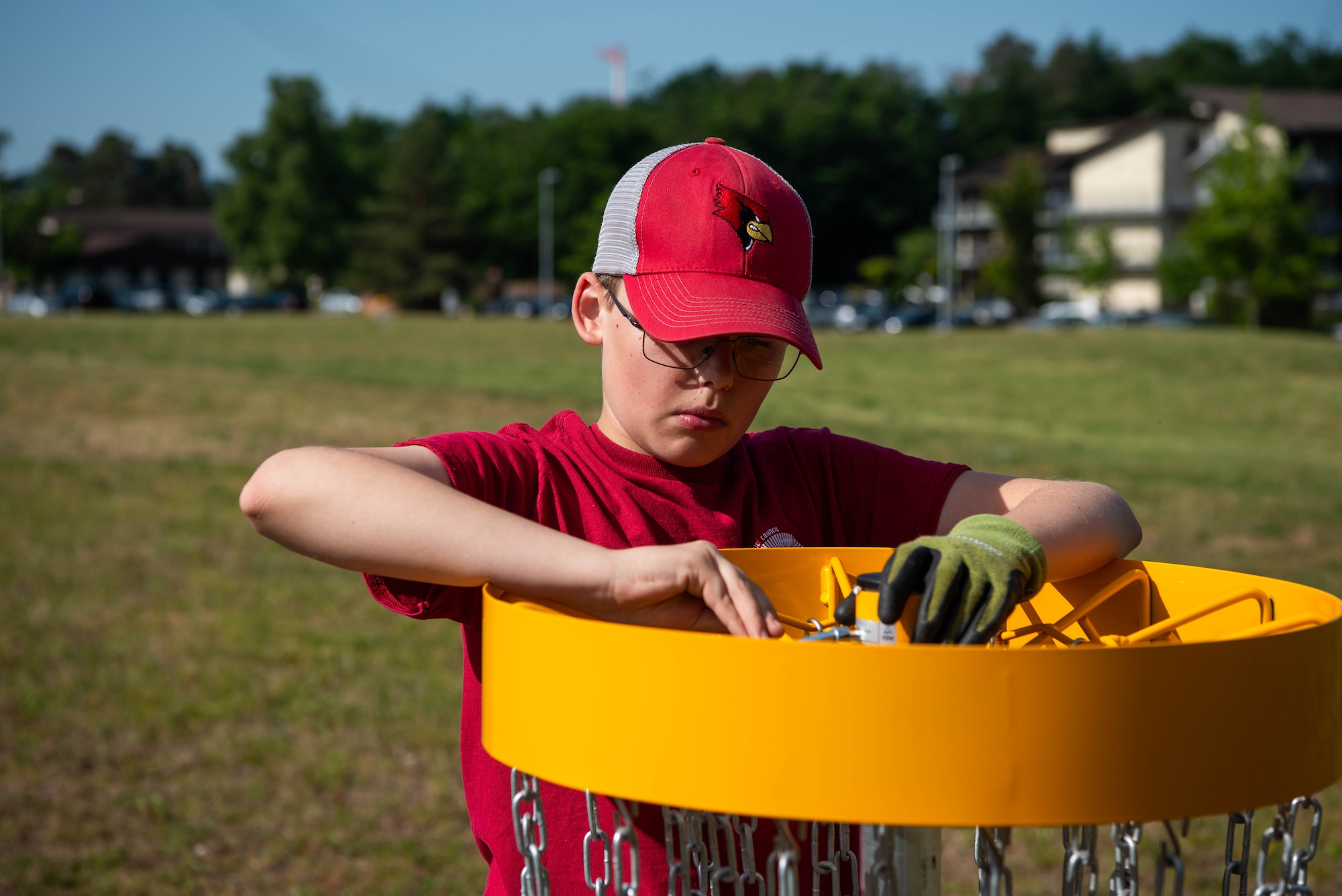 A Boy Scout of America member installs a disc golf basket.