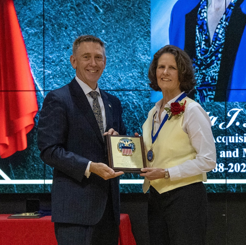 Linda Kelly receives her Hall of Fame award from DLA Land and Maritime Acting Commander Kenneth Watson