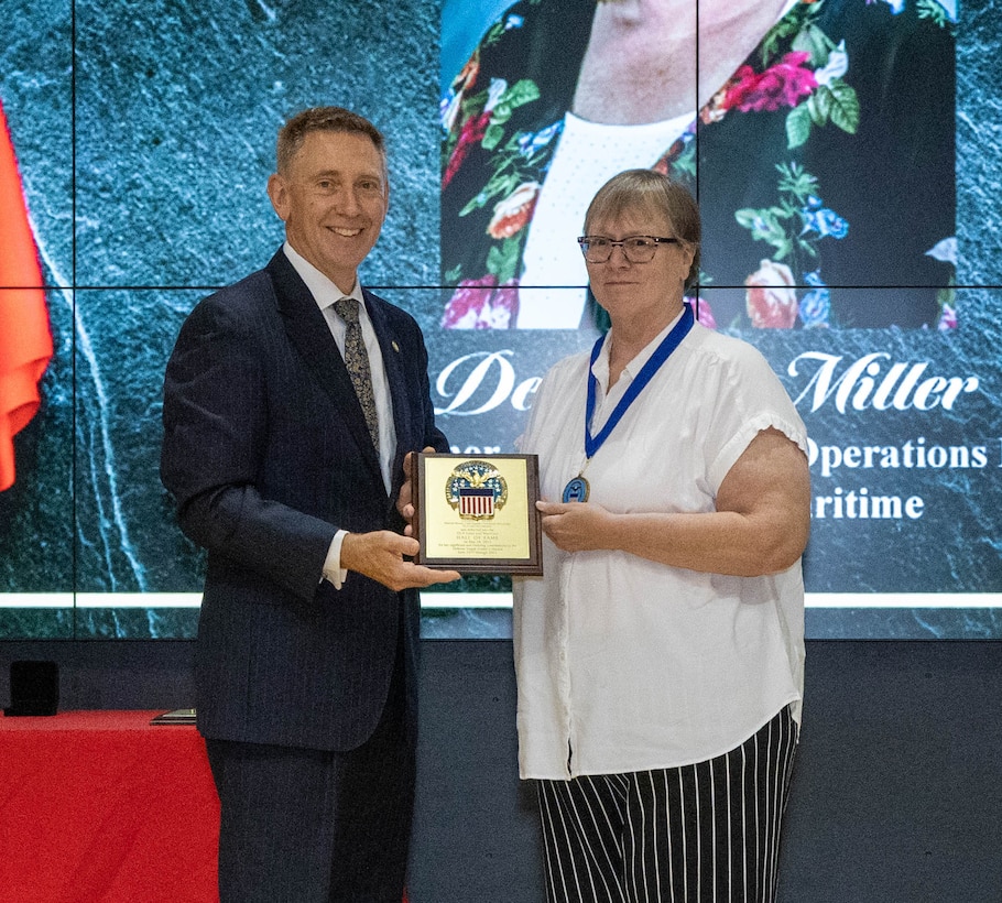 Debbie Miller receives her Hall of Fame award from DLA Land and Maritime Acting Commander Kenneth Watson