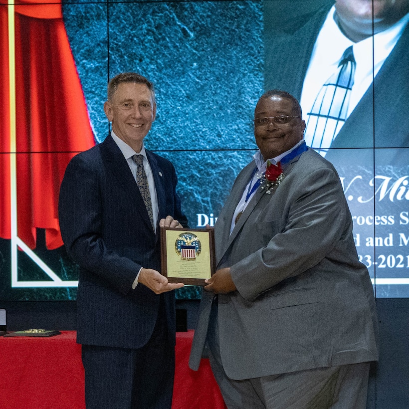 Oscar Mitchell receives his Hall of Fame plaque from DLA Land and Maritime Acting Commander Kenneth Watson