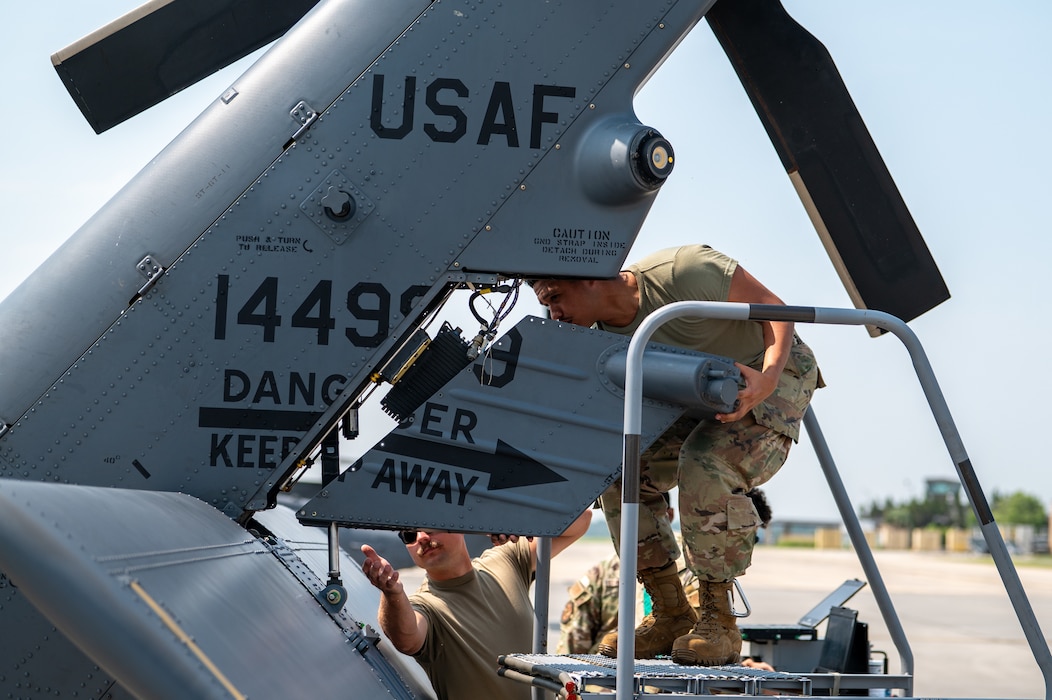 Men work on helicopter.