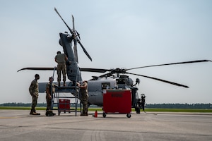 Men work on a helicopter.