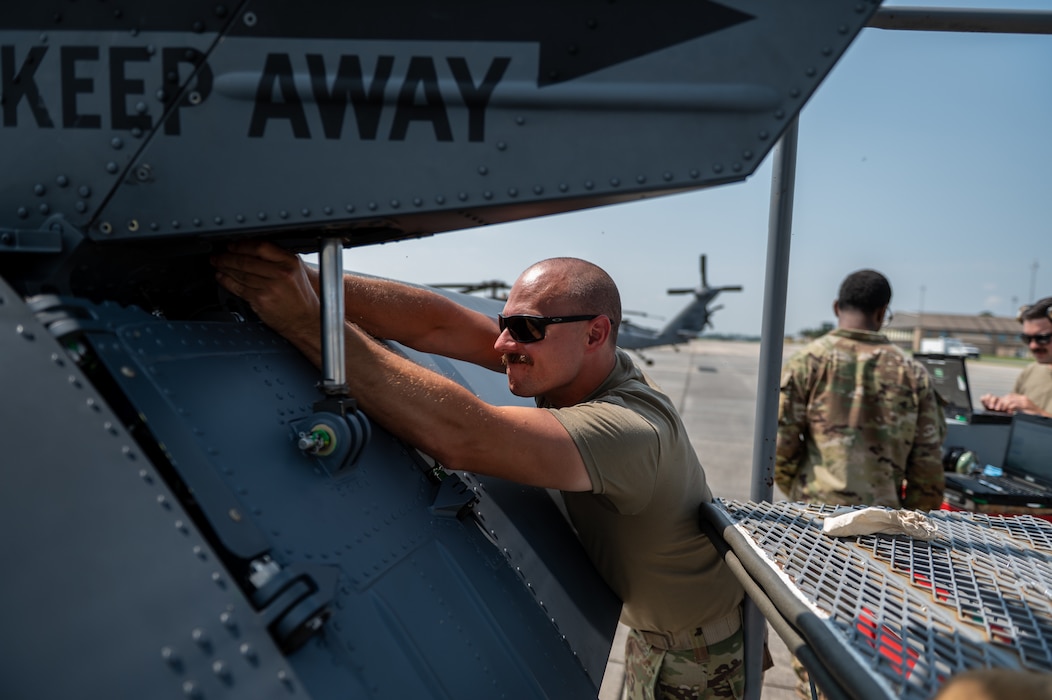 Man wearing sunglasses checks on equipment.