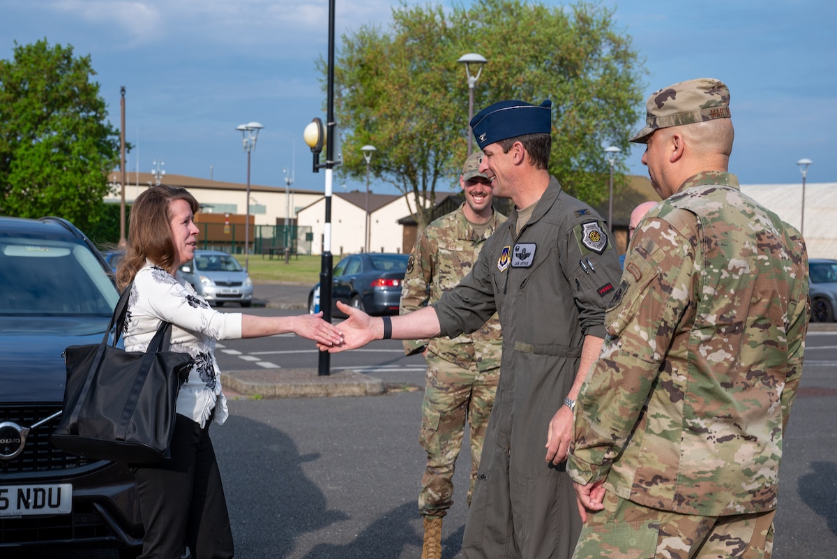 A base commander shakes hands with a member of the Department of the Air Force