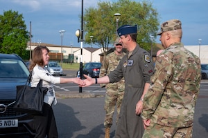 A base commander shakes hands with a member of the Department of the Air Force