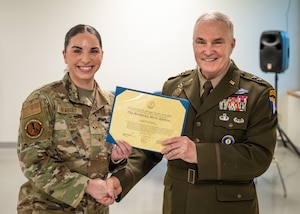 Senior Airman Carolyn Peabody, left, is one of 11 members of the 123rd Airlift Wing Fatality Search and Recovery Team who was recognized with two decorations during a ceremony at the Kentucky Air National Guard Base in Louisville, Ky., April 13, 2025, for disaster-recovery work following Hurricane Helene in North Carolina. The Airmen each received a Kentucky National Guard Merit Ribbon and a North Carolina National Guard State Active Duty Ribbon from U.S. Army Maj. Gen. Haldane Lamberton, Kentucky's adjutant general, for exceptional and meritorious service from Oct. 2 to 14, 2024, in Asheville, N.C., where they managed the case records of 79 victims, processed 48 remains, directly contributed to the identification of 21 deceased and dedicated more than 13 hours to search and recovery operations, collaborating seamlessly with the FBI, local authorities and other FSRT units. (U.S. Air National Guard photo by Dale Greer)