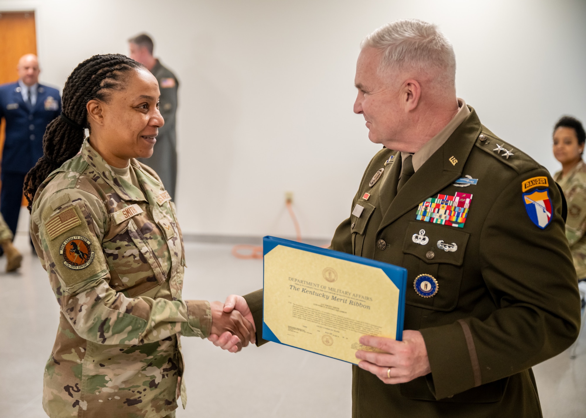 Airman 1st Class Ebony Smith, left, is one of 11 members of the 123rd Airlift Wing Fatality Search and Recovery Team who was recognized with two decorations during a ceremony at the Kentucky Air National Guard Base in Louisville, Ky., April 13, 2025, for disaster-recovery work following Hurricane Helene in North Carolina. The Airmen each received a Kentucky National Guard Merit Ribbon and a North Carolina National Guard State Active Duty Ribbon from U.S. Army Maj. Gen. Haldane Lamberton, Kentucky's adjutant general, for exceptional and meritorious service from Oct. 2 to 14, 2024, in Asheville, N.C., where they managed the case records of 79 victims, processed 48 remains, directly contributed to the identification of 21 deceased and dedicated more than 13 hours to search and recovery operations, collaborating seamlessly with the FBI, local authorities and other FSRT units. (U.S. Air National Guard photo by Dale Greer)