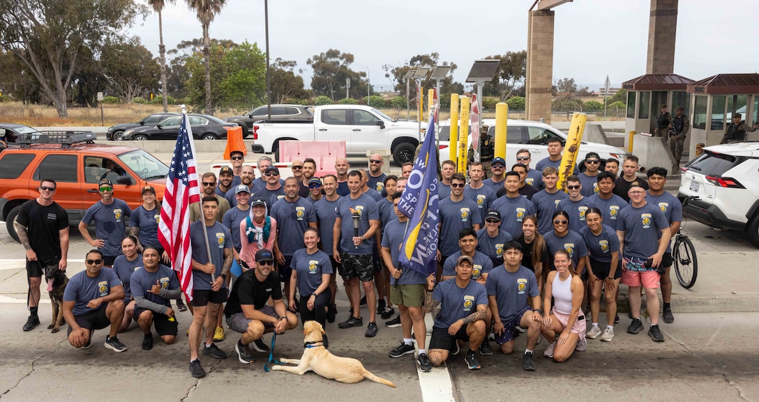 Marines and law enforcement officers and agents with the Provost Marshal Office, NCIS, and Criminal Investigation Division, Marine Corps Base Camp Pendleton, pose for a group photo with their counterparts from the Oceanside Police Department and Oceanside California Highway Patrol during the 2025 Law Enforcement Torch Run for Special Olympics in Southern California at MCB Camp Pendleton, California, May 28, 2025. The LETR in Southern California is over a 950-mile-long run completed throughout more than 200 Southern California communities by over 1,100 military and law enforcement personnel from various city, county, state, and federal agencies. (U.S. Marine Corps photo by Cpl. Jacqueline Akamelu)