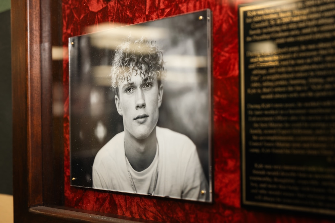 A portrait of U.S. Marine Corps Pvt. Kyle D. Siminak hangs in a conference room dedicated to him at the Marine Combat Training Battalion, School of Infantry–West, Marine Corps Base Camp Pendleton, California, May 23, 2025. A commemoration ceremony was held to honor Pvt. Siminak’s service and sacrifice following his passing during training on Dec. 7, 2024. Family members, friends, and fellow Marines gathered to remember and celebrate his life. (U.S. Marine Corps photo by Sgt. Patrick King)