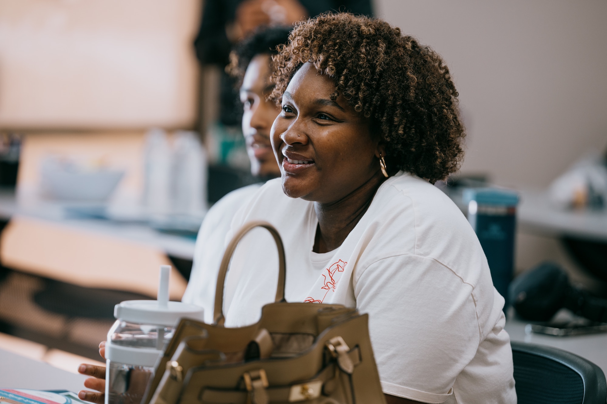 U.S. Air Force Airmen and spouses smile during Retired Maj. Gen. Edward Thomas Jr., Air Force Aid Society chief executive officer’s visit at the Military and Family Readiness Center.