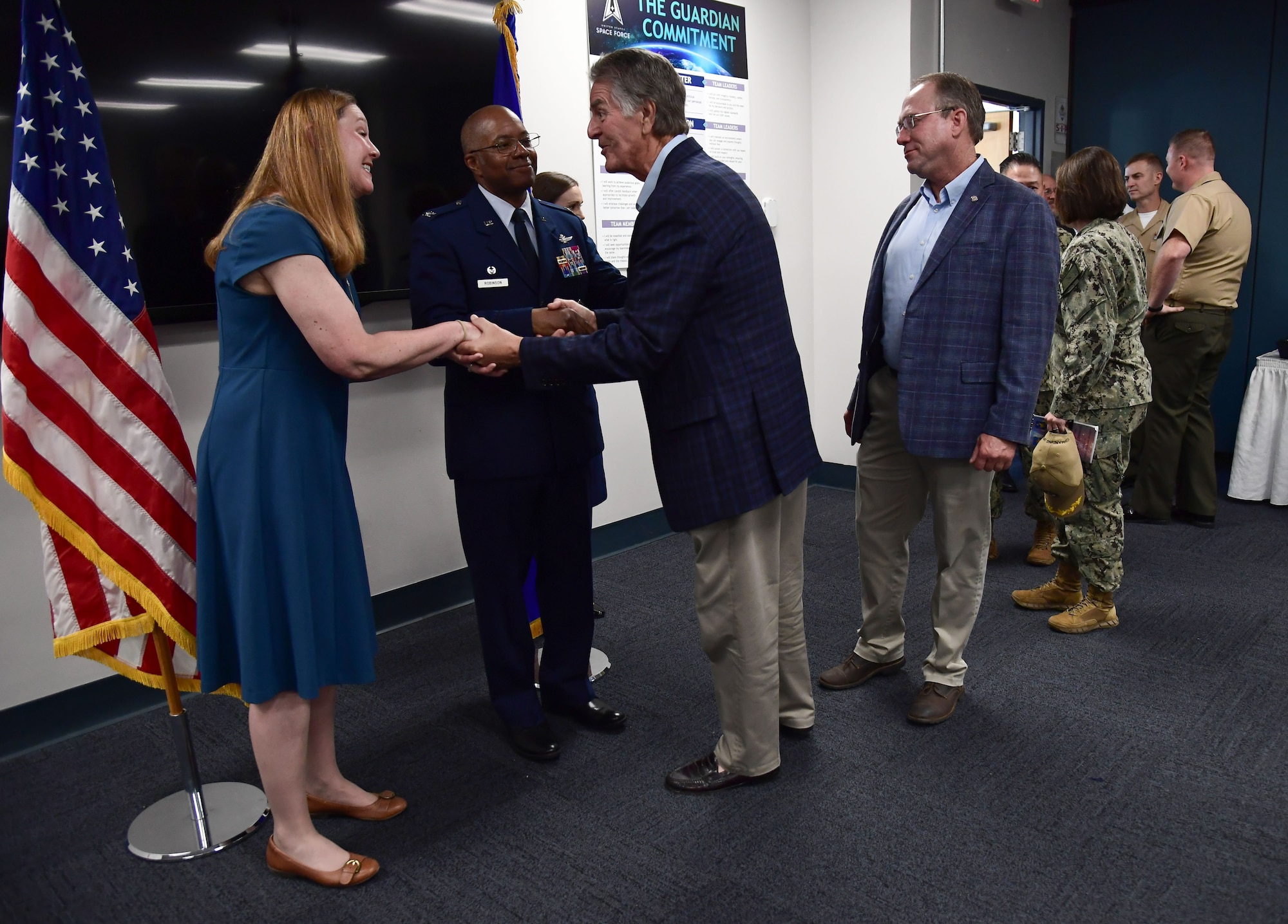 An airman shaking hands with a gentleman.