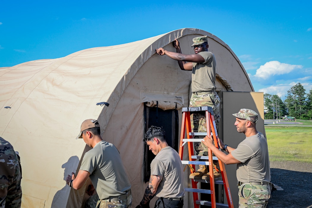 Four Airmen construct a Small Shelter System tent.