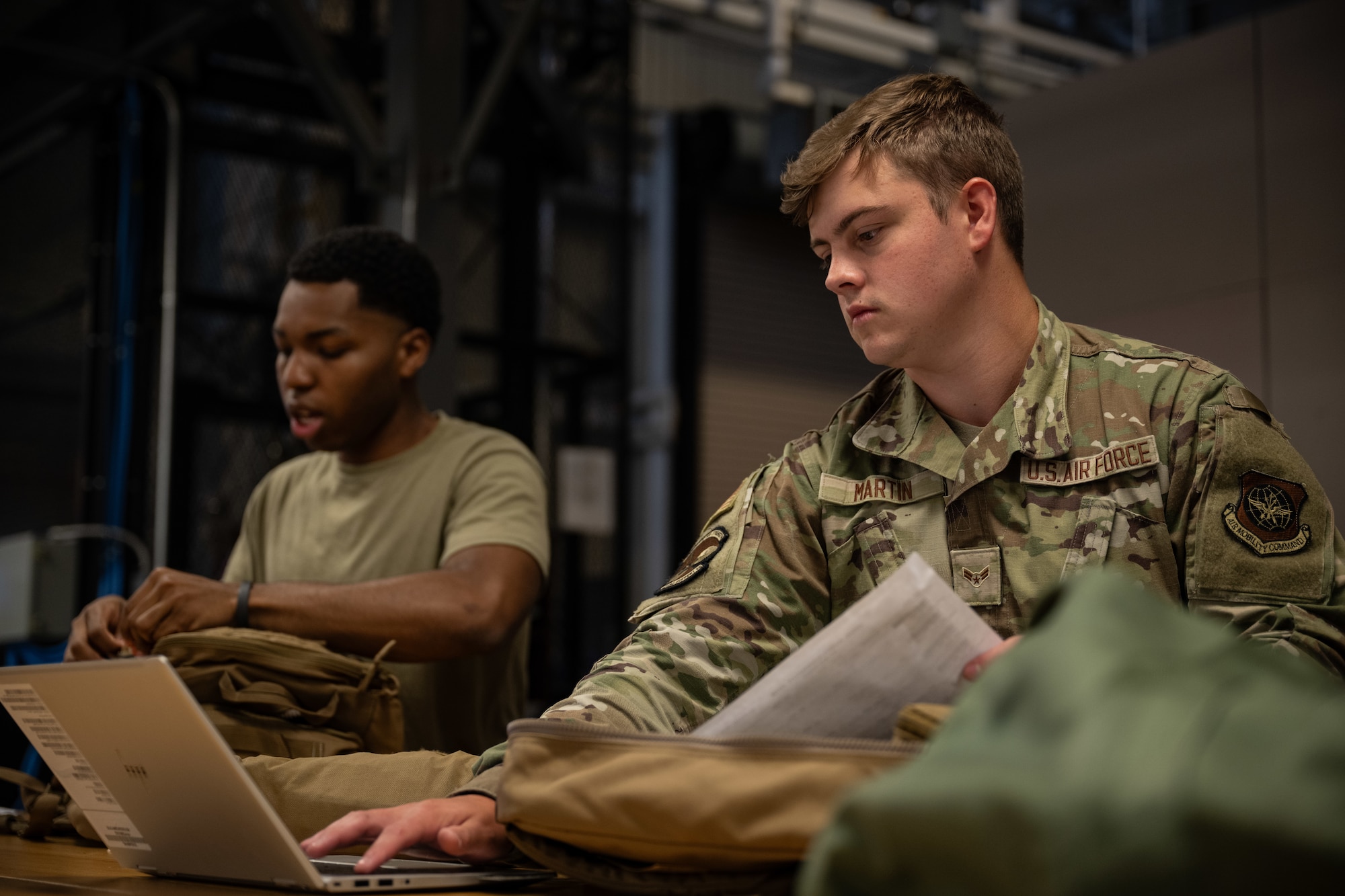 U.S. Airman 1st Class Rylan Martin, right, and Airman 1st Class Ray Wilson, left, 436th Operations Support Squadron Aircrew Flight Equipment journeymen, use a computer to inspect A-3 bags at Dover Air Force Base, Delaware, June 3, 2025. The AFE team provides inspections and maintenance for flight safety equipment such as aircrew oxygen masks, parachutes, emergency escape slides and life rafts for the C-5M Super Galaxy and C-17 Globemaster III. (U.S. Air Force photo by Staff Sgt. Marco A. Gomez)