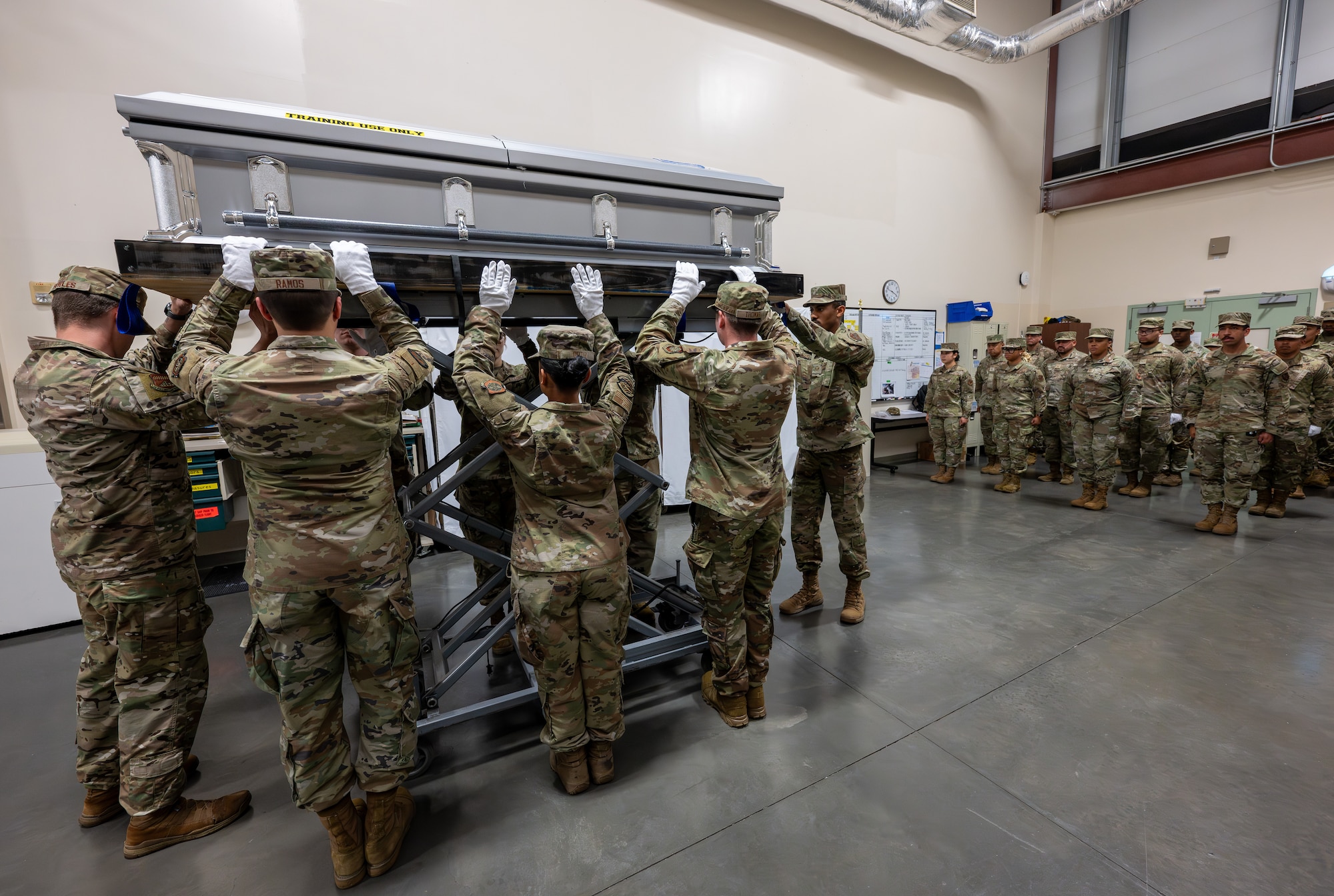 Airmen with the 436th Mission Generation Group secure a casket as it is raised up