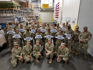 Airmen pose for a group photo with their certificates