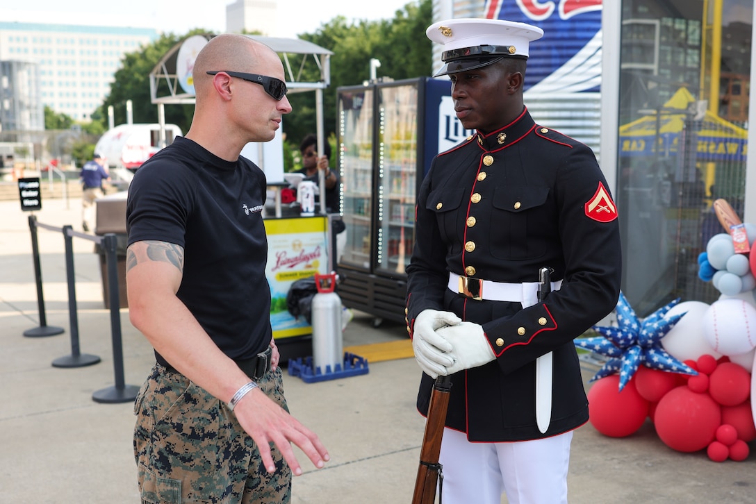 U.S. Marine Corps Staff Sgt. Cameron Madden, staff non-commissioned officer in charge, Recruiting Sub-Station Clarksville, Recruiting Station Nashville, left, speaks with Lance Cpl. Jalen Jones, a rifleman with the Silent Drill Platoon, Marine Barracks Washington, at the Nashville Sounds Rock’n’Jock Celebrity Softball game as part of Marine Week Nashville, in Nashville, June 2nd, 2025. During Marine Week Nashville, Marines with Marine Corps Recruiting Command interacted with local high schools and businesses and supported sporting events, ceremonies and performances from the Silent Drill Platoon and the 2nd Marine Aircraft Wing Band. The Marine Corps is celebrating its 250th birthday with six multi-day Marine Corps community events, called Marine Weeks, in six major cities across the country. Marine Weeks will include activations across each host city featuring aircraft, equipment, recruiting opportunities, and public engagements. (U.S. Marine Corps photo by Lance Cpl. Brenna Ritchie)