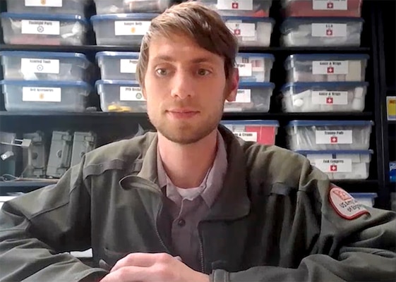 A USACE Park Ranger in uniform sits at desk.
