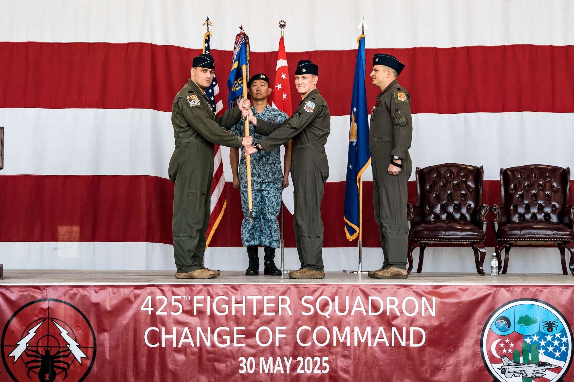 U.S. Air Force Col. Oliver Lause, 56th Operations Group commander, hands the guidon to Lt. Col. Andrew Bolint, incoming 425th Fighter Squadron commander, during the 425th FS Change of Command Ceremony