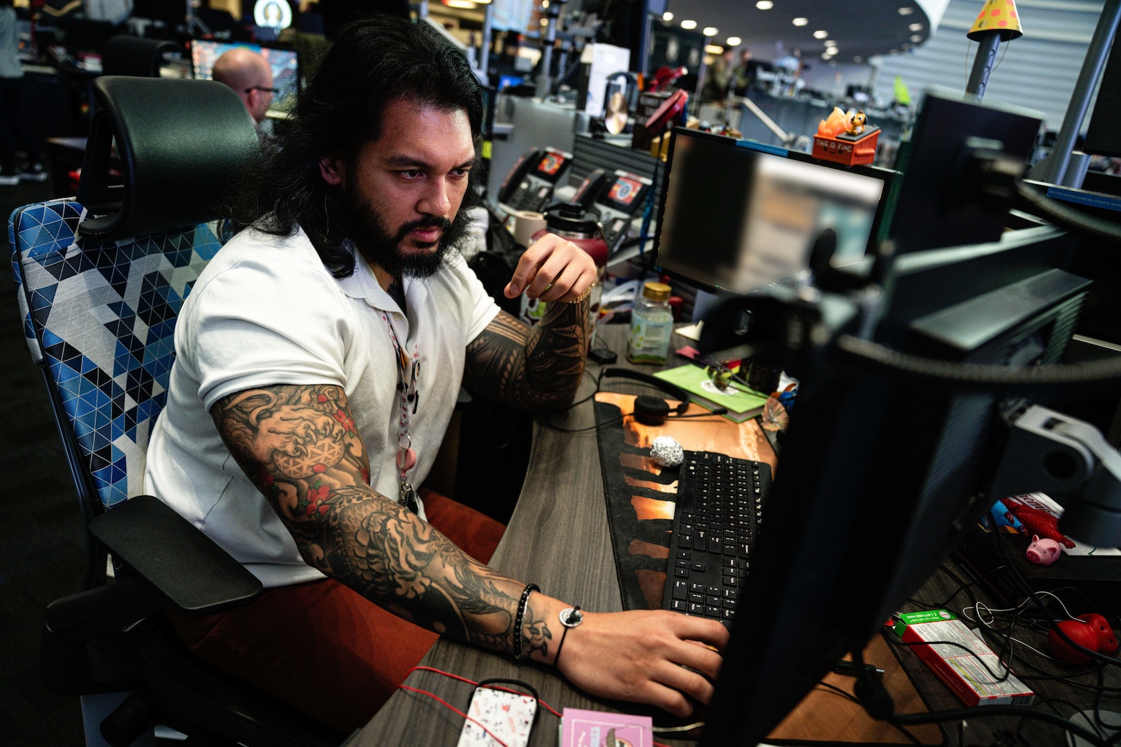 A man in business casual attire working at a computer.