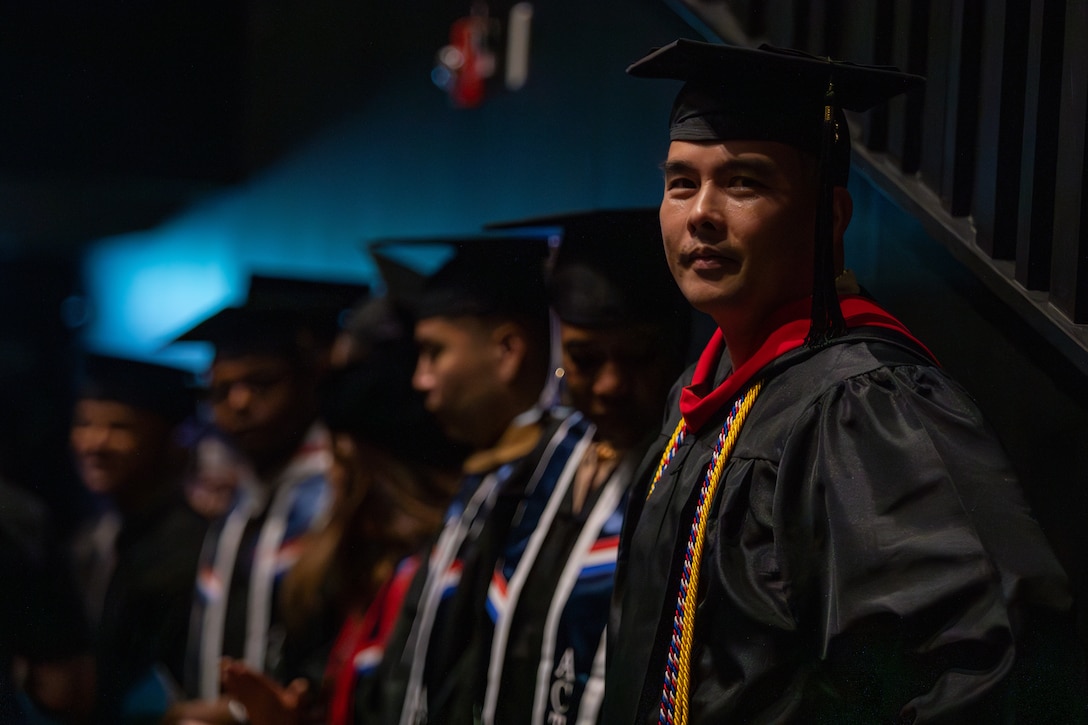 U.S. Navy Master Chief Petty Officer Erwin Jerome Angeles, a maintenance chief with Airborne Command and Control Squadron (VAW) 125, stands in line during the 2024-2025 college graduate recognition ceremony at Marine Corps Air Station Iwakuni, Japan, May 30, 2025. The ceremony celebrated the graduates’ completion of higher education while serving in the MCAS Iwakuni community. (U.S. Marine Corps photo by Sgt. Isaac Orozco)