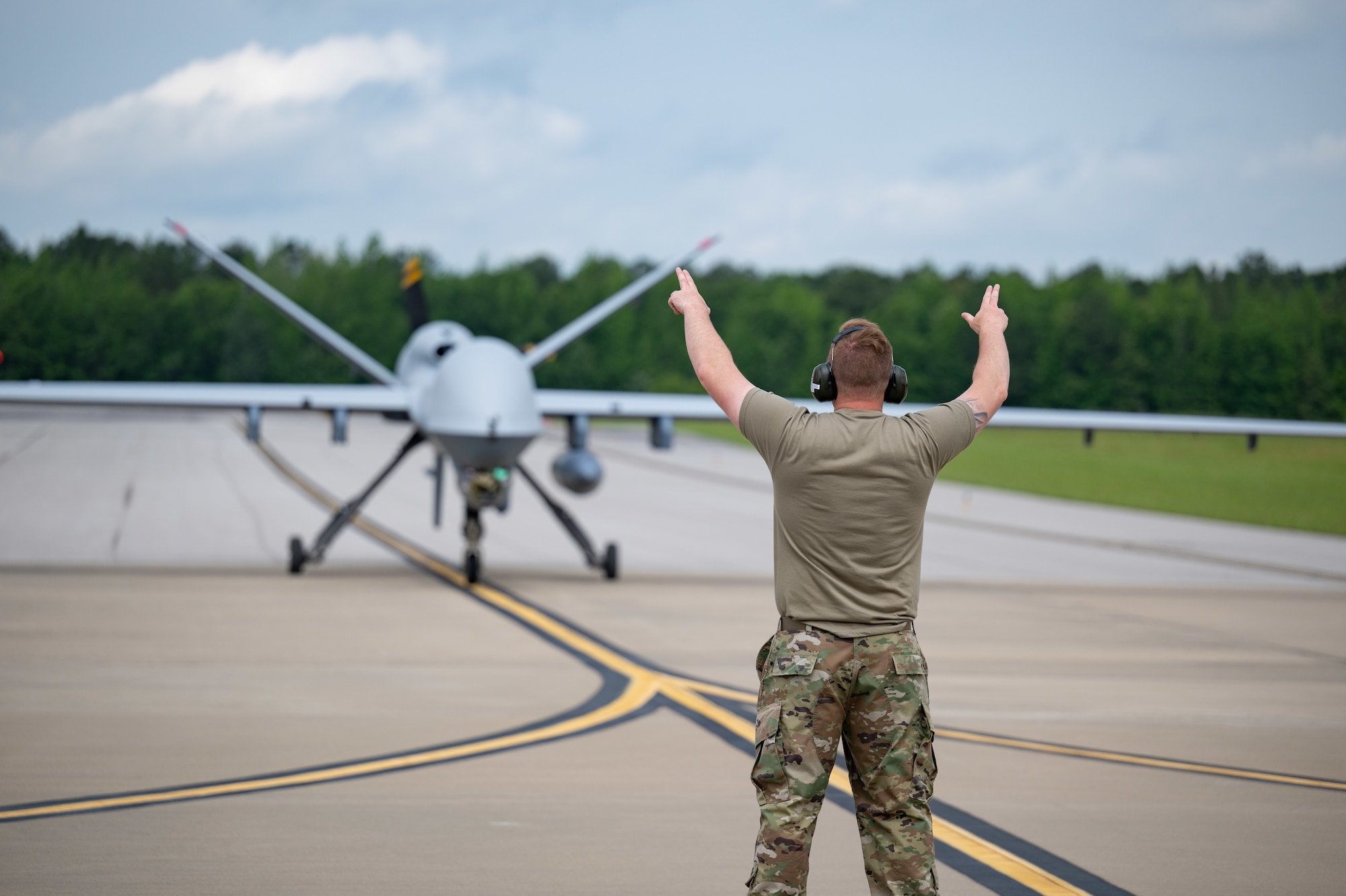 Tech Sgt. Andrew Tverberg, crew chief with the 119th Wing, North Dakota Air National Guard, directs the landing of an MQ-9 Reaper on the airfield at Arnold Air Force Base, Tenn., May 14, 2025. The aircraft was used in support of Vigilant Guard, an annual disaster response exercise. Arnold AFB was involved in the portion of Vigilant Guard 2025 focused on airfield management and fuel transfer missions. Guardsmen from the Tennessee National Guard and the North Dakota National Guard were on hand at Arnold to perform the exercise. Arnold AFB Fire and Emergency Services crews supported the effort by maintaining a presence during the arrival and departure of aircraft and throughout the refueling. Arnold crews also received hands on familiarization with the MQ-9 from Guardsmen present. (U.S. Air Force photo by Keith Thornburgh)