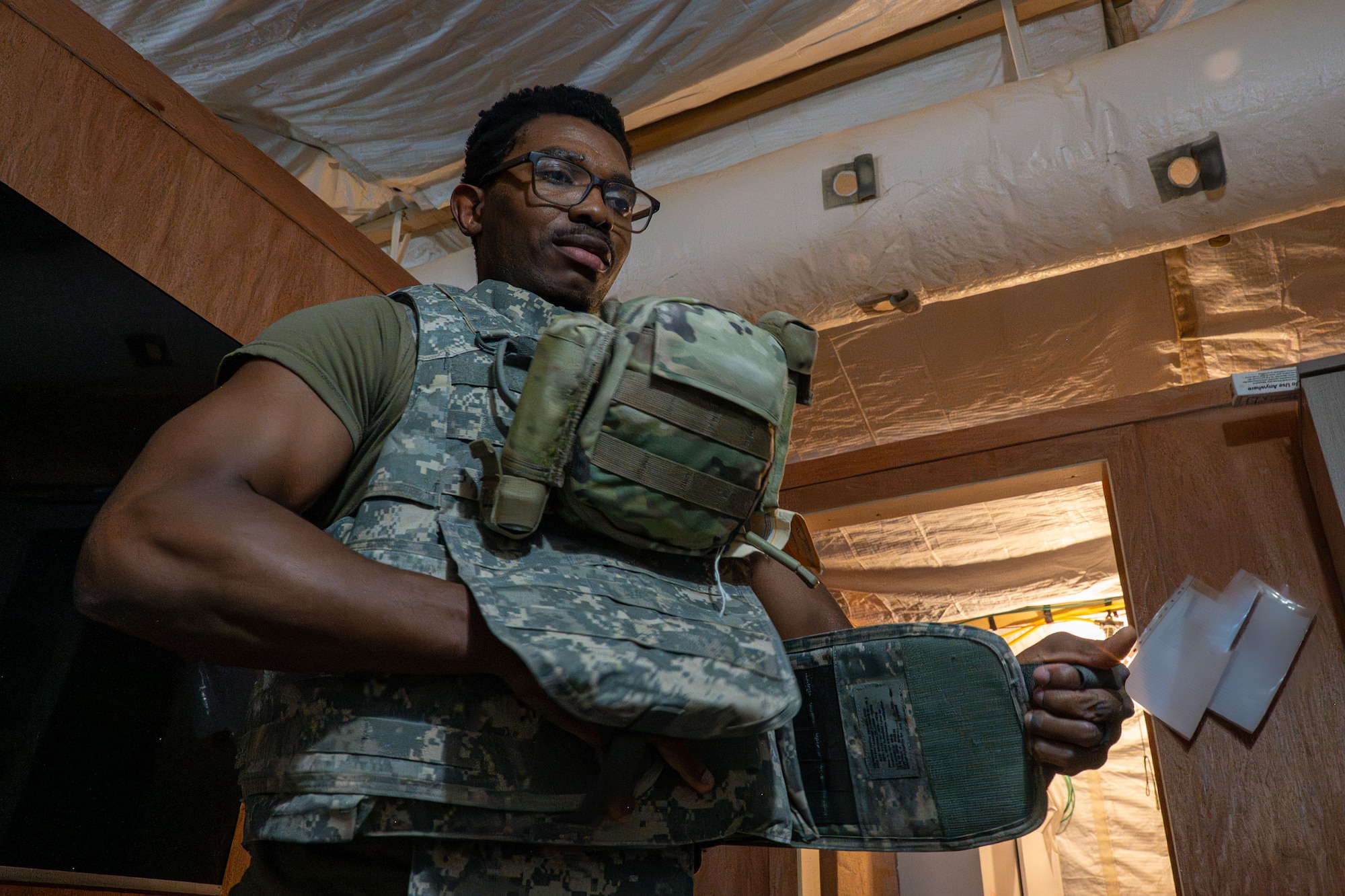 A man tightens the side flaps on his tactical vest.