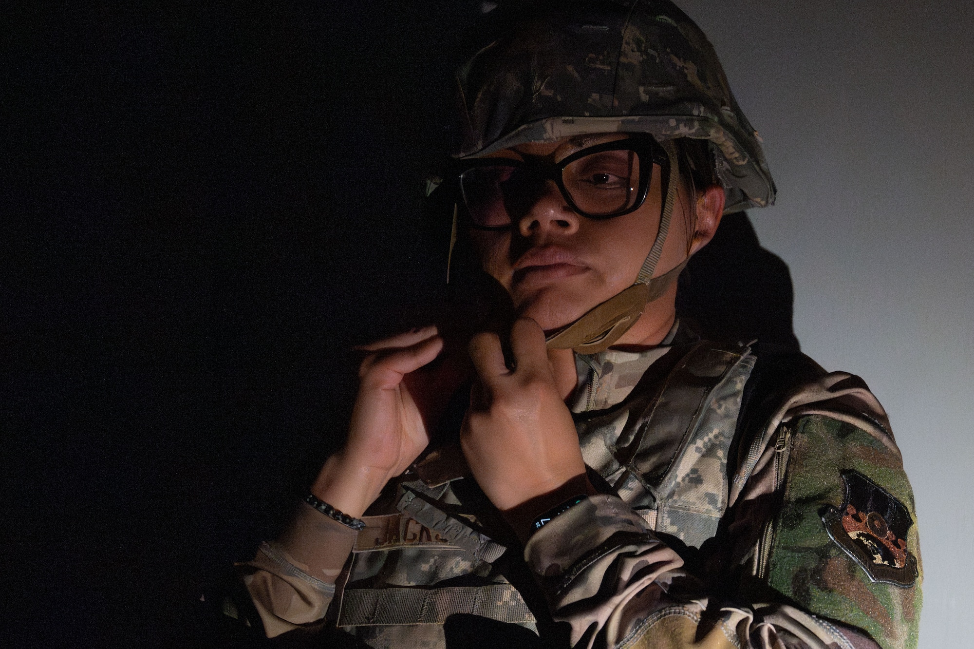 A woman fastens the strap on her helmet.