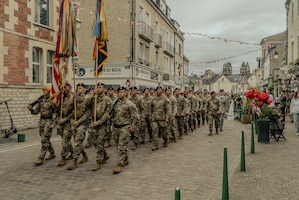 Soldiers marching through the streets of Carentan
