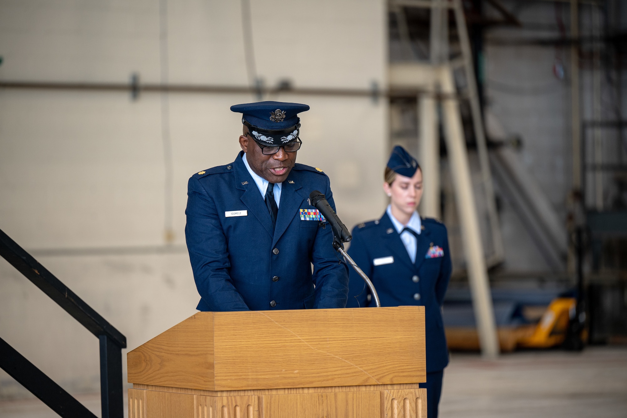 U.S. Air Force Maj. Joseph Idomele, 436th Airlift Wing deputy chaplain, gives the invocation during the 436th AW change of command ceremony on Dover Air Force Base, Delaware, May 30, 2025. Upon taking command, Col. Jamil Musa became the wing’s 38th commander. Standing next to Idomele is Capt. Kaylam Keil, 436th Medical Group medical information system flight commander, who served as the ceremony narrator. (U.S. Air Force photo by Senior Airman Trenten Walters)
