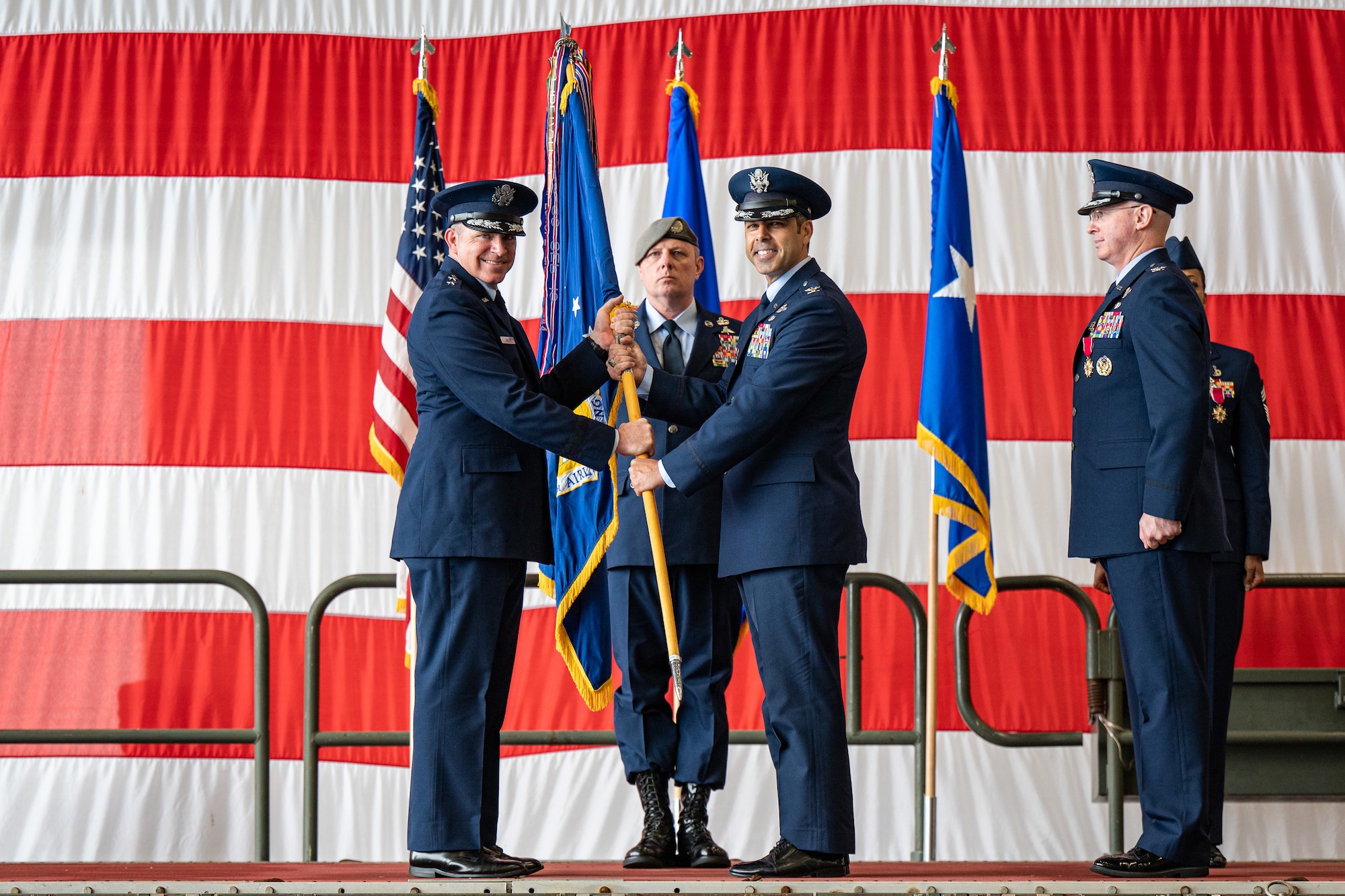 U.S. Air Force Maj. Gen. Charles Bolton, Eighteenth Air Force commander, presents the 436th Airlift Wing guidon to Col. Jamil Musa, 436th AW commander, during a change of command ceremony on Dover Air Force Base, Delaware, May 30, 2025. Upon taking command, Musa became the wing’s 38th commander. (U.S. Air Force photo by Senior Airman Trenten Walters)