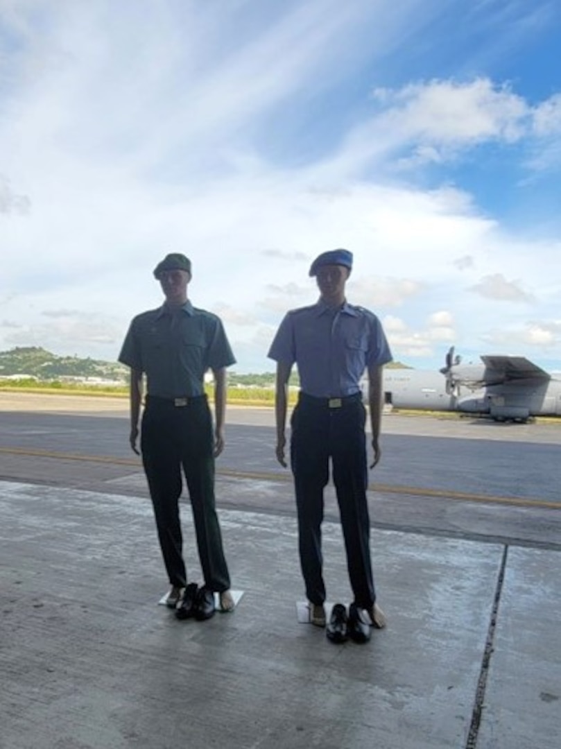 two mannequins wearing uniforms stand near airport runway