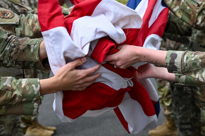 Airmen fold a flag
