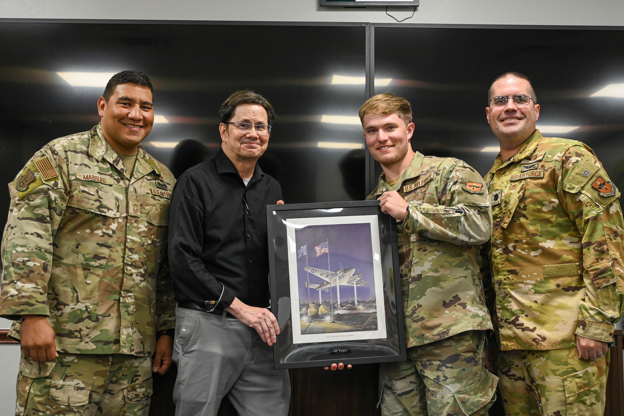 David Pelino, 97th Comptroller Squadron (CPTS) unit program coordinator, center left, is given a retirement gift from members from 97th CPTS at Altus Air Force Base, Oklahoma, May 28, 2025. After 46 years, Pelino retired from civil service on June 6, 2025. (U.S. Air Force photo by Senior Airman Kari Degraffenreed)